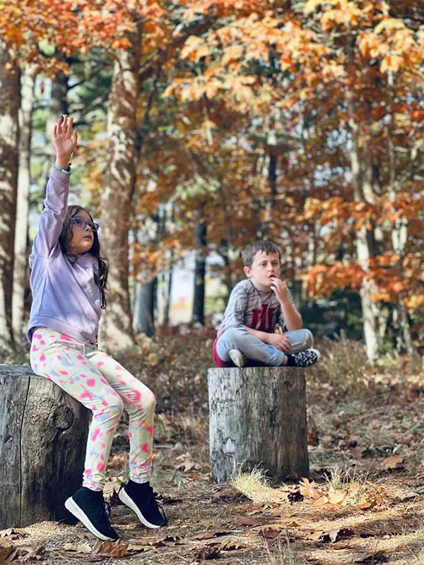 child in outdoor lesson raising hand
